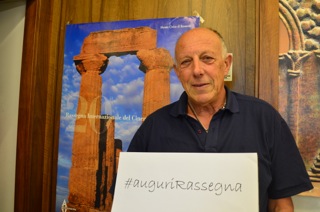 Dario Di Blasi, direttore della Rassegna, mostra l'hashtag #auguri Rassegna