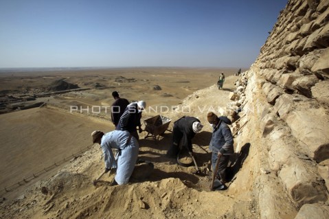 Operai al lavoro sul fianco della piramide che domina la piana di Saqqara