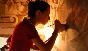 Una giovane restauratrice al lavoro su un affresco