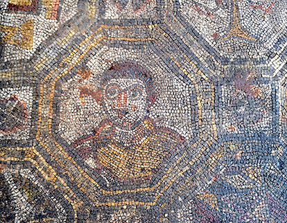 Il busto umano raffigurato all'interno di una cornice ottagona sul pavimento musivo della villa dell'Oratorio
