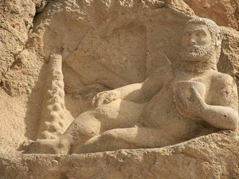 La statua colossale di Ercole nudo scolpita sulla roccia nel sito archeologico di Bisotun (Iran occidentale)