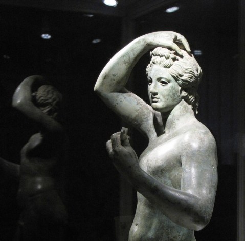 L'Efebo di Sutri: figura maschile giovanile, con il braccio destro sul capo e il sinistro piegato in modo da portare ad altezza del volto un oggetto ora mancante, forse uno specchio