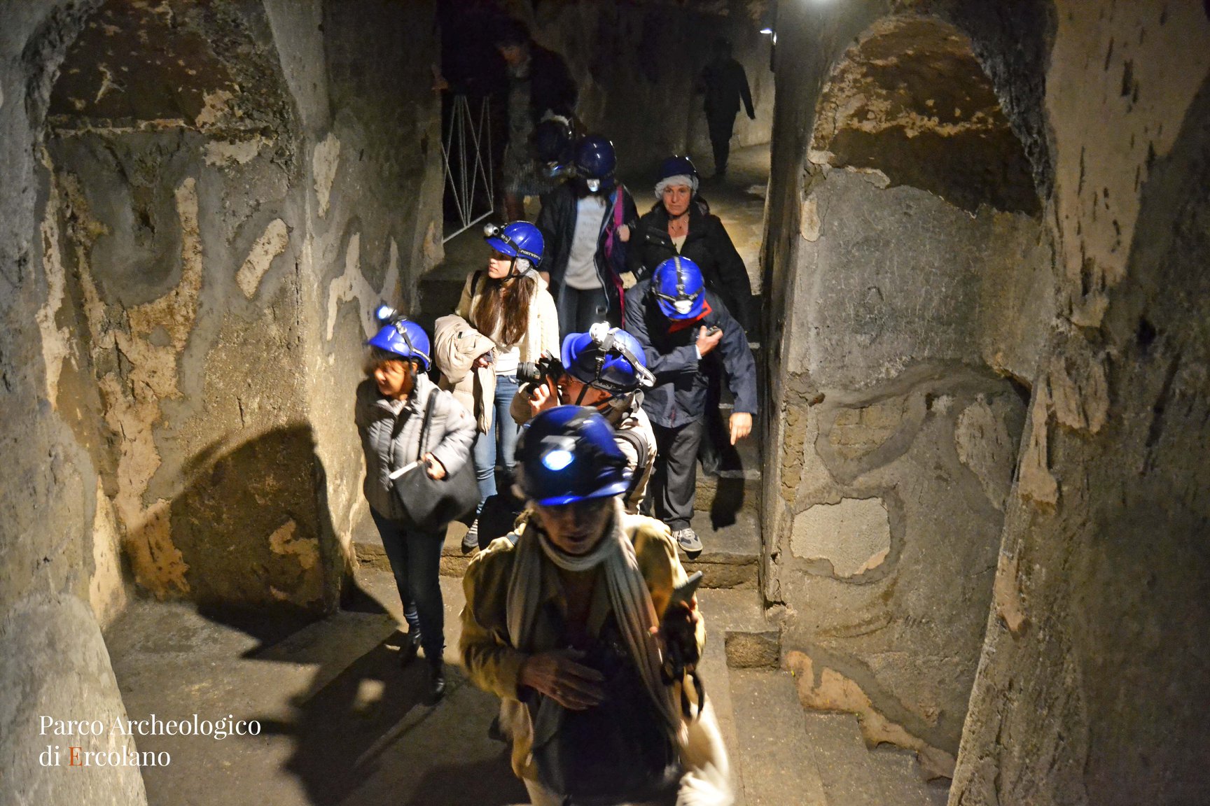 ercolano_teatro-antico_visitatori-con-torcia-e-caschetto_foto-paerco